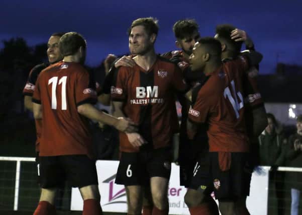 Rene Howe is mobbed by his Kettering Town team-mates after scoring their winner against Dorchester Town. Pictures by Peter Short