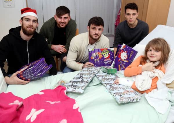 Poppies Christmas: Kettering: KGH Skylark Ward visit by Poppies players  l-r Paul White, Paul Malone, James Haran, Lewis Hornby with Mollie Brophy-Williams, 8,  Tuesday December 13, 2016 NNL-161213-215522009
