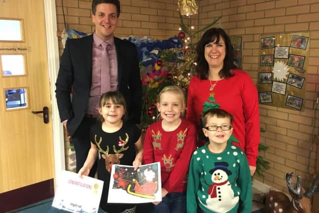 Mark Swindells from Croyland Car Megastore is headteacher Jan Marshall and pictured in the front row - from left to right - is competition winner Eliyah Takara with her certificate and winning design alongside fellow pupils Niamh Inglis and Robert Hazell.
