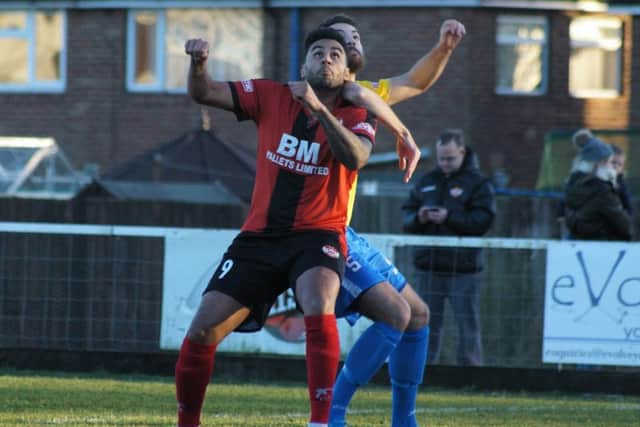 Rene Howe battles for a high ball with King's Lynn Tom Ward