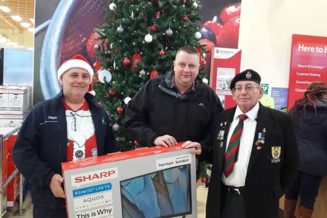 Alan being presented with his TV by Tesco community champion Mick Brown (left) and Cliff Morton, from The Charity Pot.