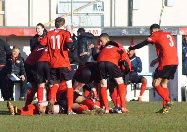 Liam Canavan is buried under a pile of his Kettering Town team-mates after his stunning strike opened the scoring in the 3-1 win over Biggleswade Town. Pictures by Peter Short
