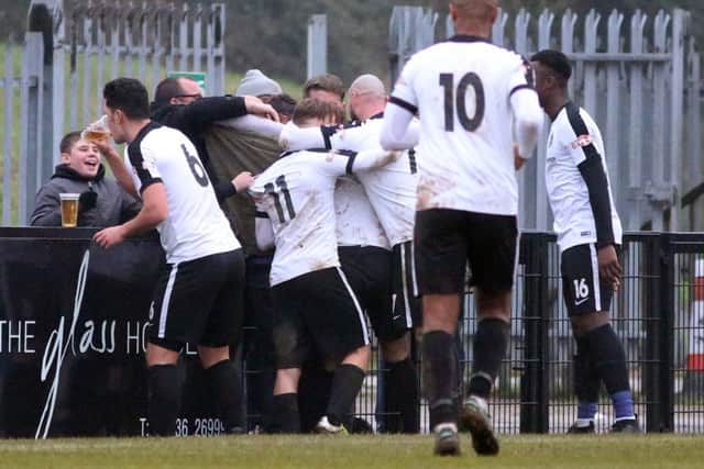 Jason Lee enjoys a little drink as Corby Town celebrate Ben Milnes' winning goal against Mickleover Sports. Pictures by Alison Bagley