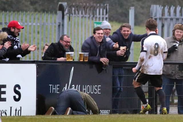 A Corby Town fan takes a tumble as he joins the celebrations with Ben Milnes after the midfielder hit the winner against Mickleover Sports. Picture by Alison Bagley