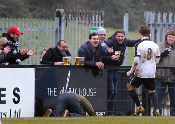 A Corby Town fan takes a tumble as he joins the celebrations with Ben Milnes after the midfielder hit the winner against Mickleover Sports. Picture by Alison Bagley