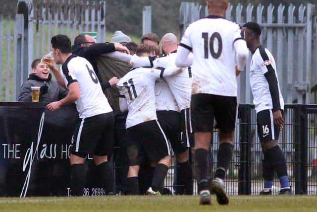 It's the picture that has taken the football world by storm over the weekens as Corby Town defender Jason Lee has a cheeky swig of a supporter's pint after Ben Milnes hit what proved to be the winner against Mickleover Sports. Picture by Alison Bagley