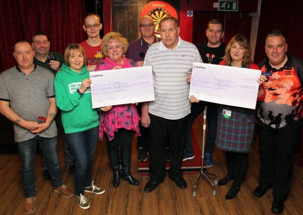 James Richardson and the darts team present Michael Elliott with cheques along with Sally Fordyce, Jan Bolt and Sheralyn Holes from Macmillan