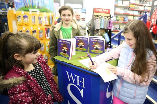Scarlett signing a copy of her book at W H Smith in Rushden