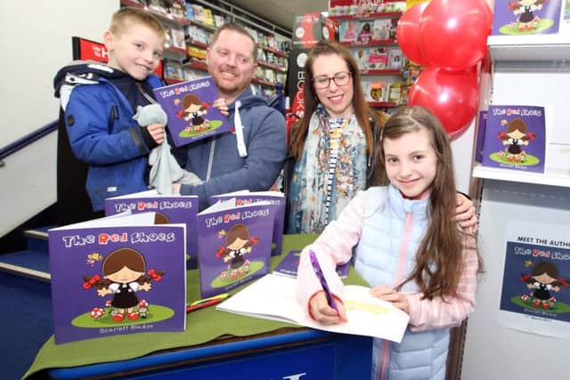 Scarlett Bladon, 10, signing copies of her book with Edward Bladon, seven, Nick Bladon and Rachel Bladon
