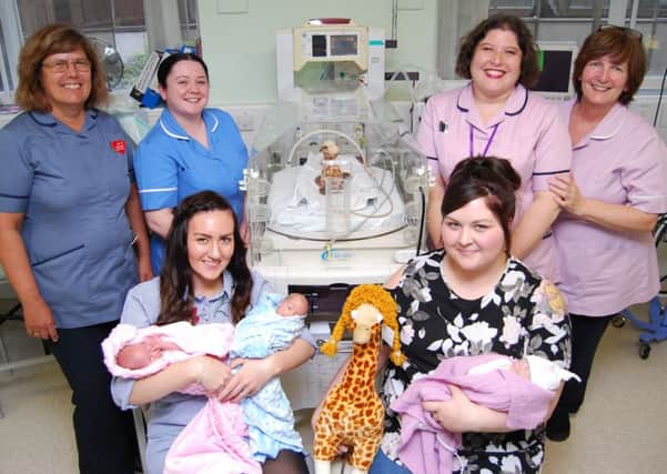 From left, matron Jeannette Payne, staff nurse Hannah Smith, Rachel Messer and her twins Indiana and Jetson, senior administrator Sara Hales, healthcare assistant Sue Harman, Stephanie Burlington and her daughter Gracie pictured with a giraffe style incubator and the appeals mascot George the Giraffe